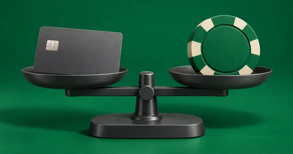 A bank card and a casino chip on the two pans of a simple balance scale