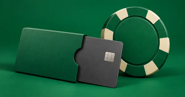 A bank card partly covered by a sleeve, next to a casino chip